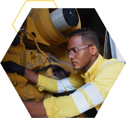 A male technician works on a Cat engine