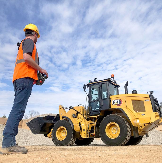 operador usando um controle remoto para operar uma pá-carregadeira de rodas.