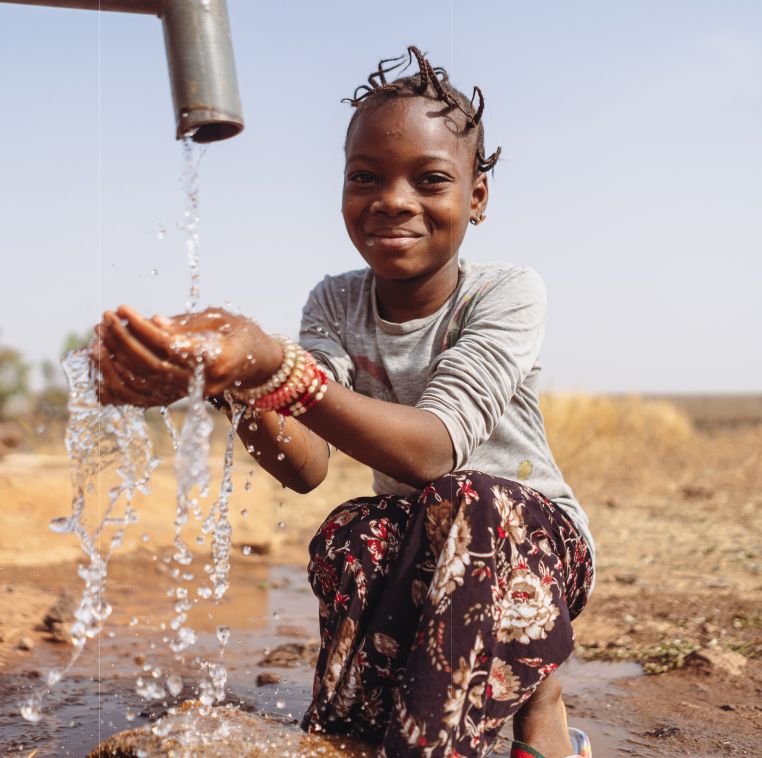 A girl rinsing her hands under running water