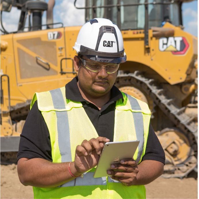 An man uses a tablet in front of a Cat D7
