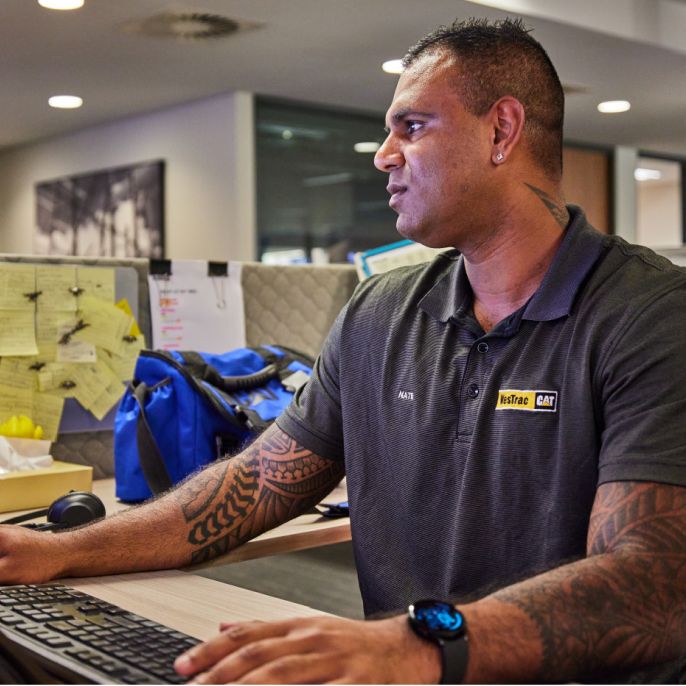 A Cat dealer employee works at a computer
