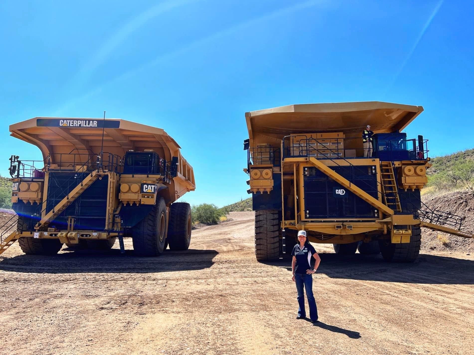Xiu in front of mining trucks