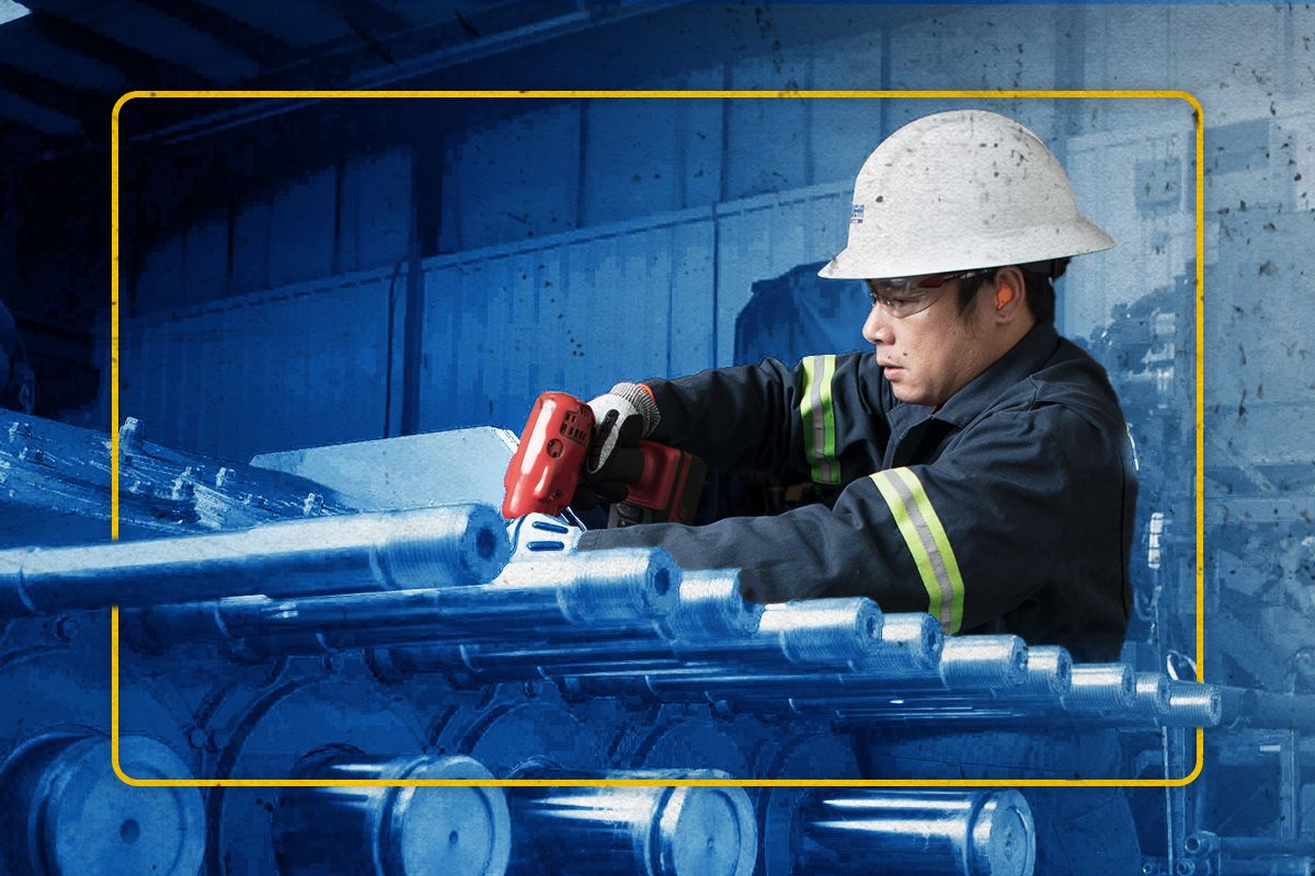 Cat worker in PPE fixing SPM parts shaded in blue