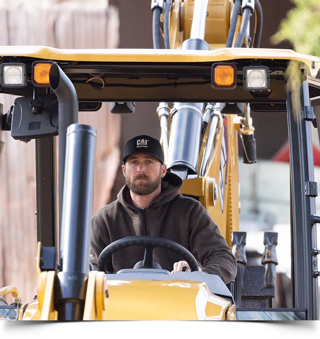 Riley operating a Cat 416 Backhoe Loader