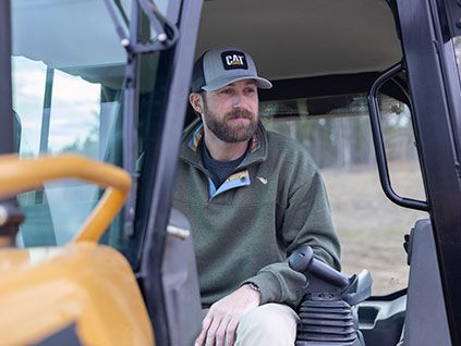 Riley Green sitting in a Cat machine