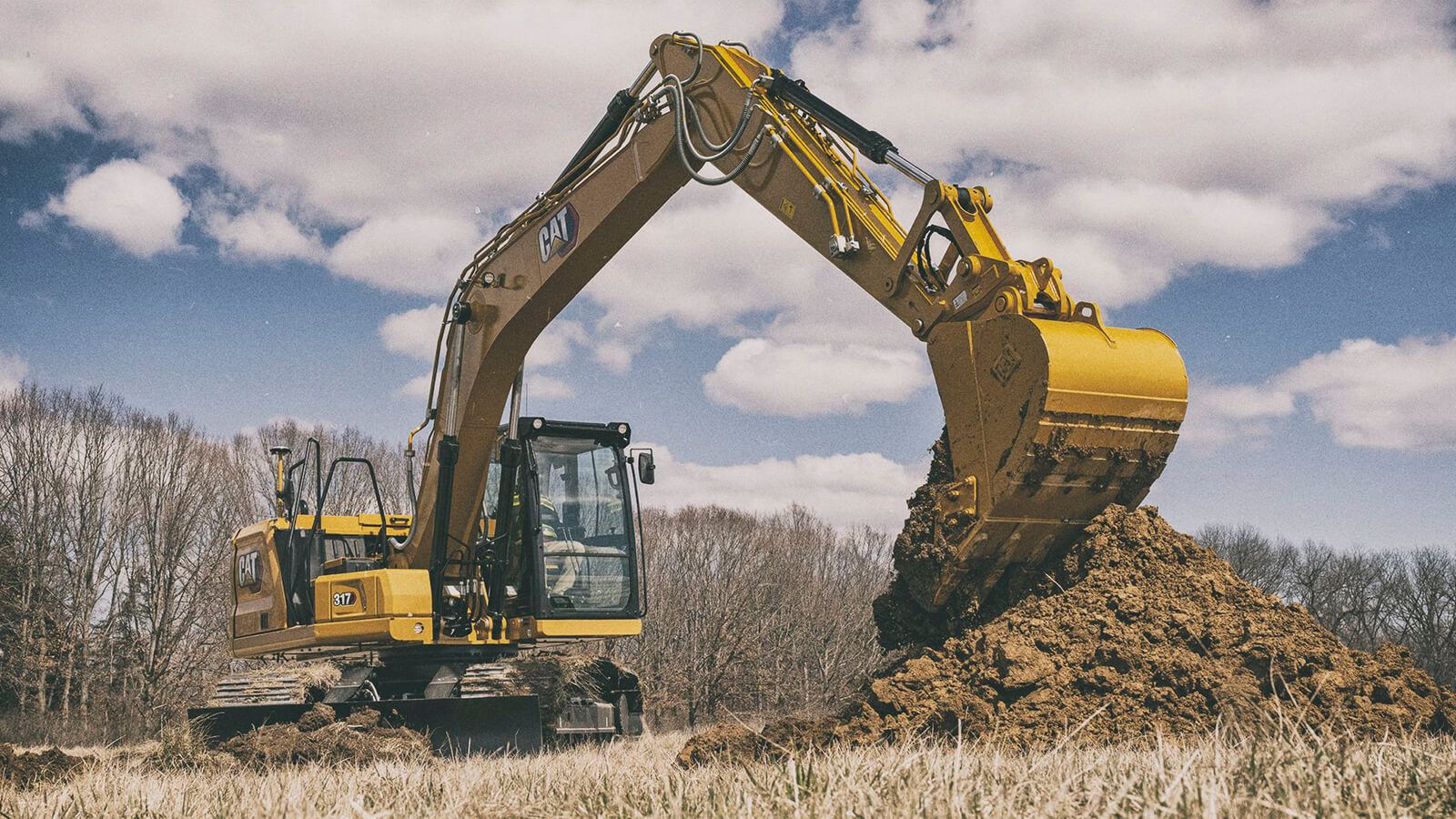 Cat 317 dumping dirt