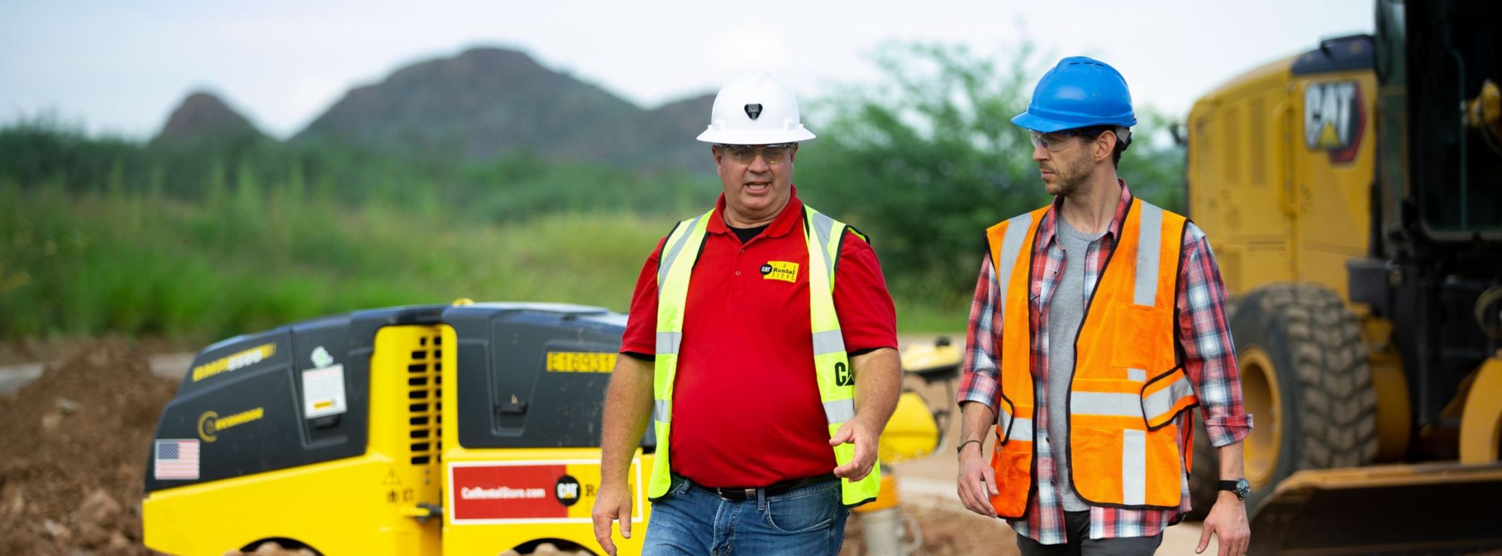 Cat Rental dealer talking to customer at worksite