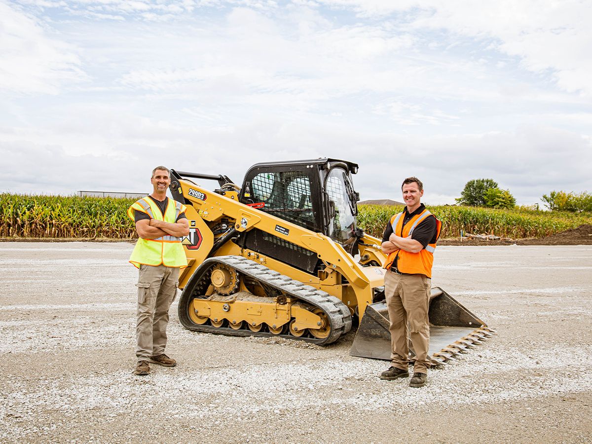 Bronson Koffer of LK & Sons Excavating and his dealer rep, Nate Nichols of Ohio Cat, standing next to Bronson's first Cat machine — a 299D3.