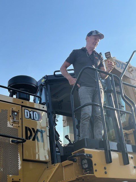 man with keys standing on dozer