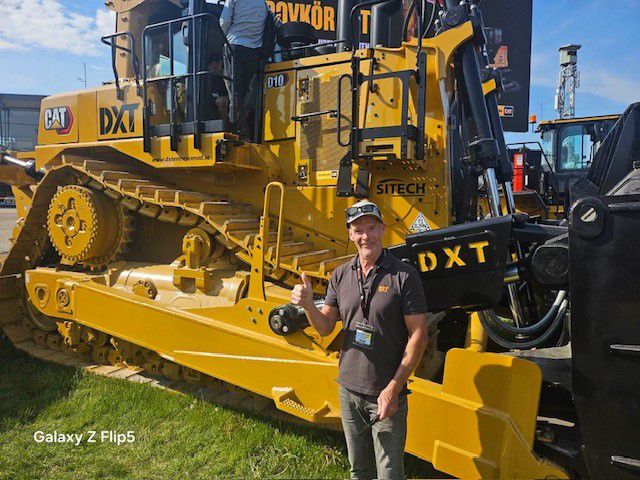 man standing next to dozer