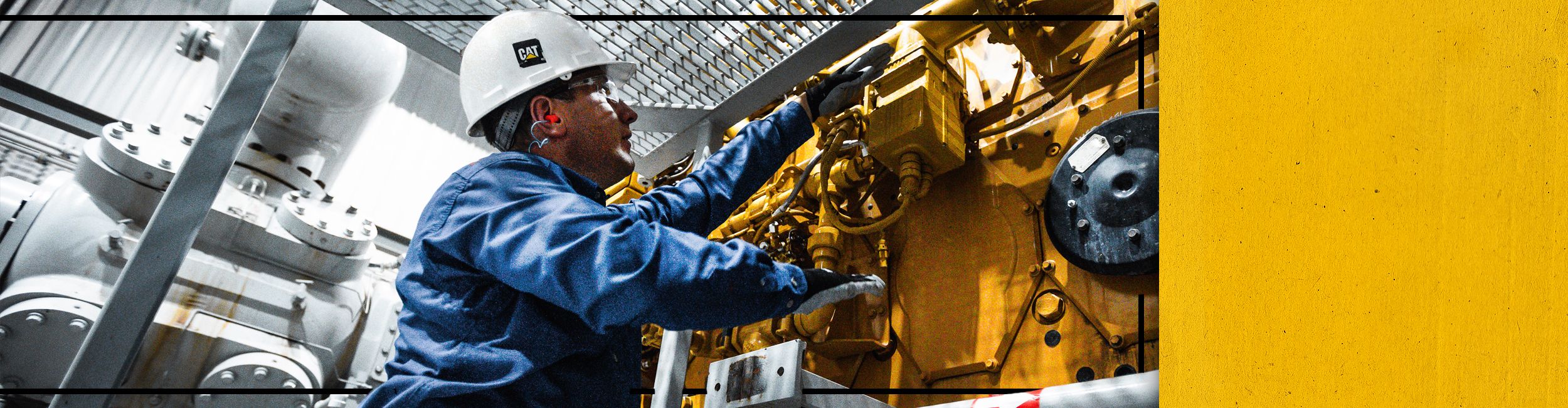 Close up of Cat worker in PPE servicing a Cat Engine