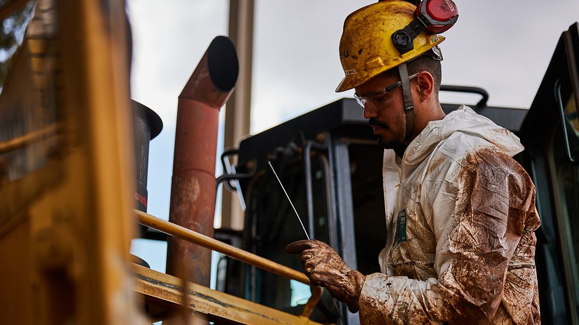 Person inspecting cat machine