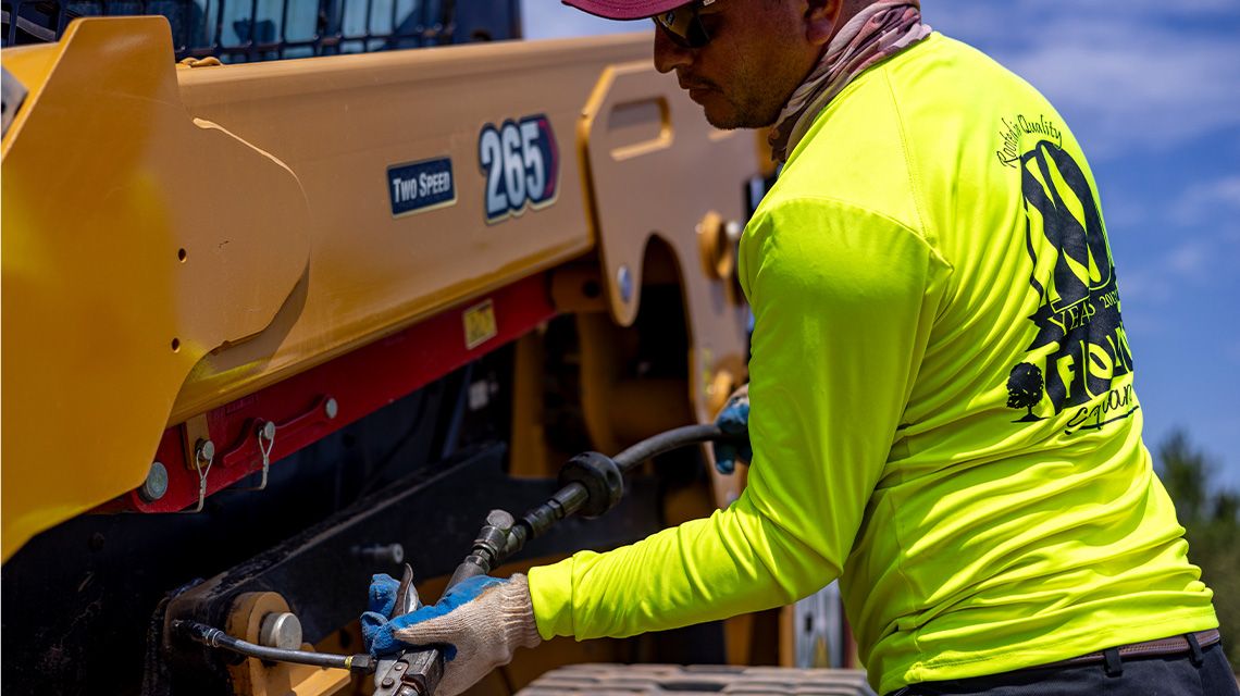 worker inspecting and repairing a machine