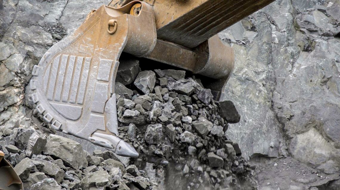 excavator bucket hauling rock