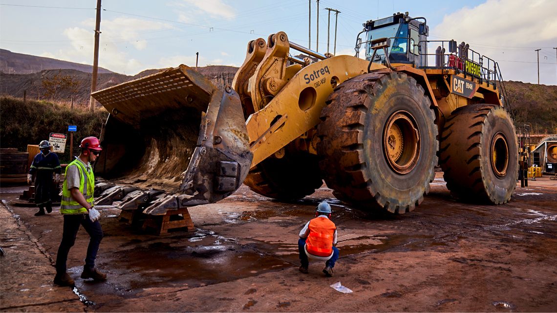 Personas de pie alrededor de un cargador de ruedas grande