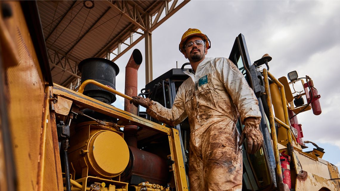 Hombre de pie en el lateral de un tractor topador grande