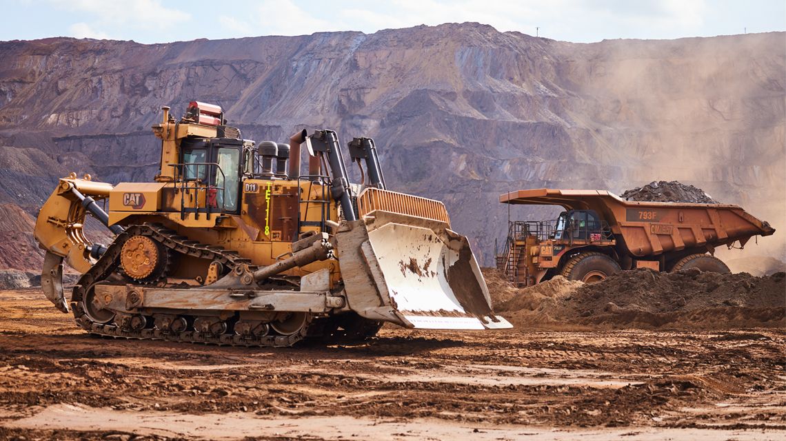 Topadora grande y camión para la minería en una explotación minera