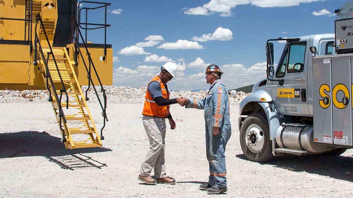 Dos hombres se dan la mano en la mina