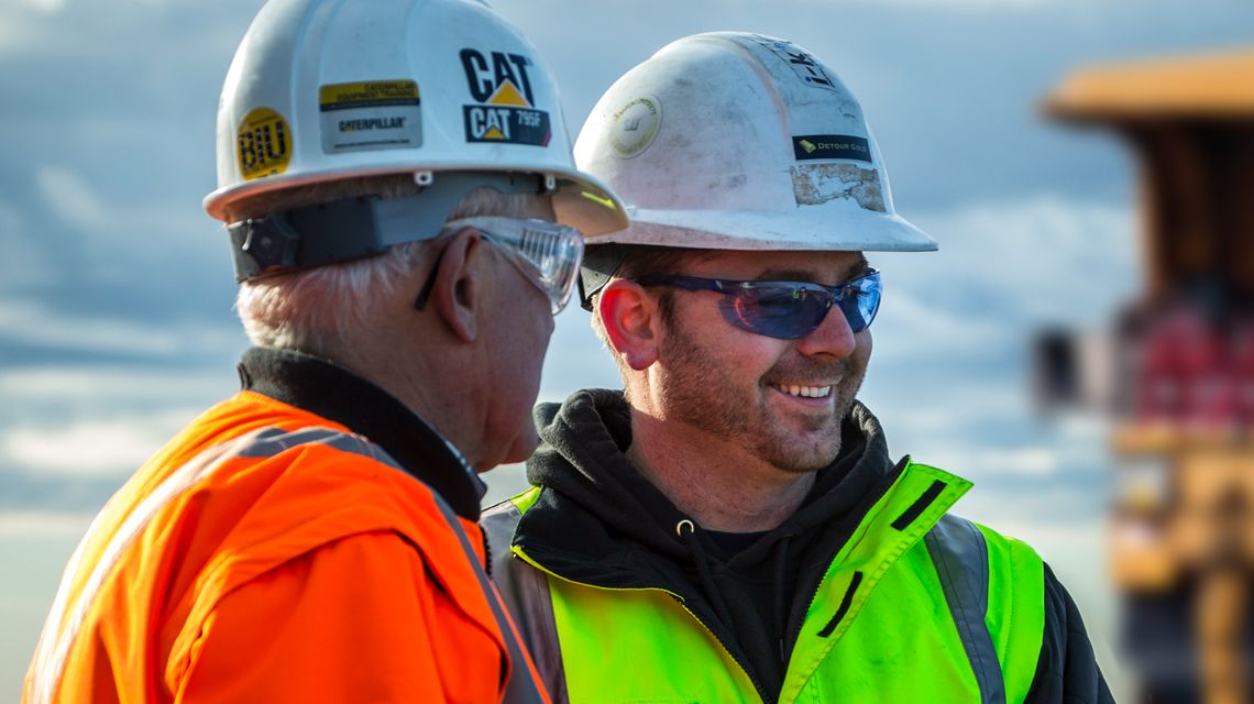 Dos personas sonriendo en una obra en construcción