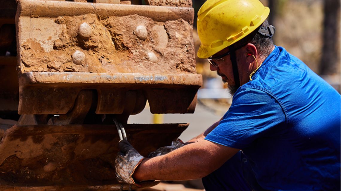 Homem fazendo a manutenção de uma máquina