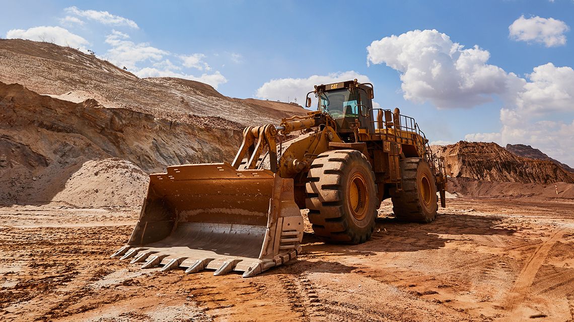 Carregadeira de rodas grande com caçamba e FPS da Cat em uma mina durante o dia