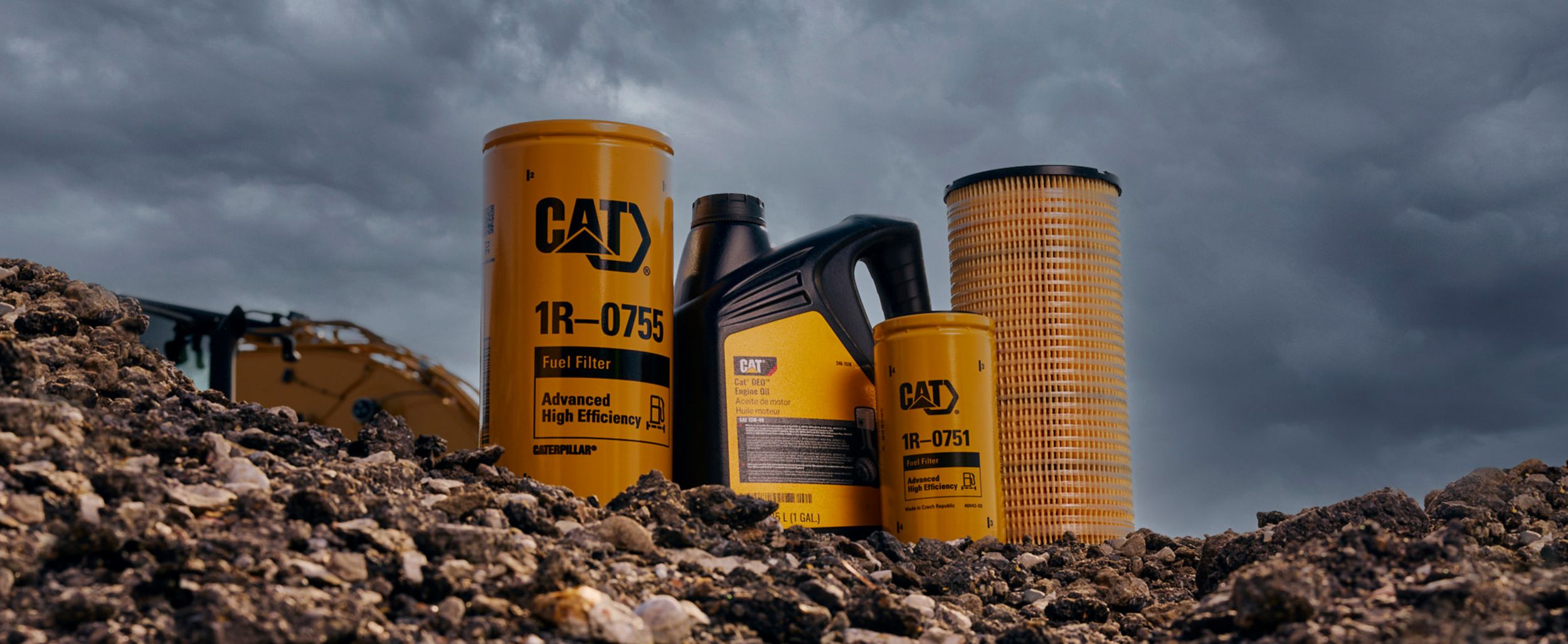 Filtros de combustível e de ar Cat e fluido de óleo do motor expostos em rochas em um canteiro de obras