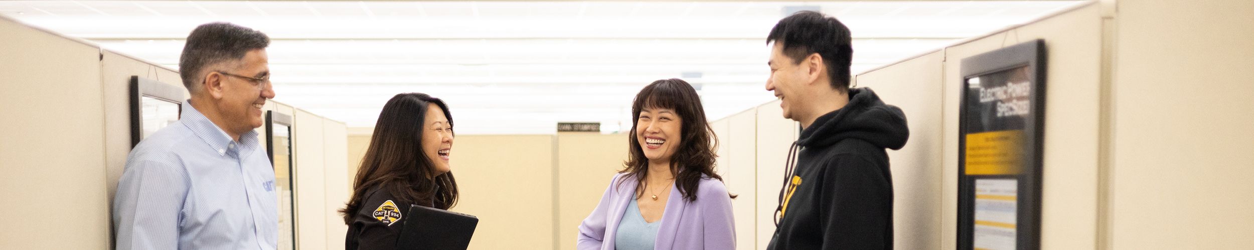 a group of four employees laughing together