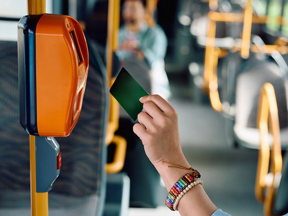 Person swipes transit card while boarding a bus