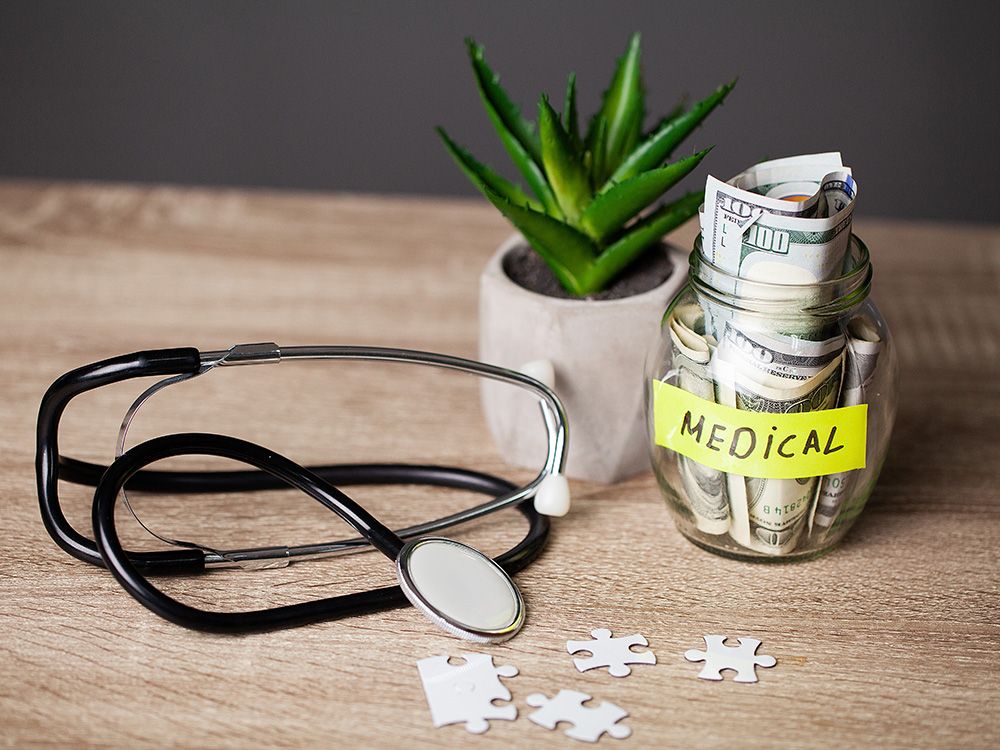 A jar full of money sits next to a stethoscope