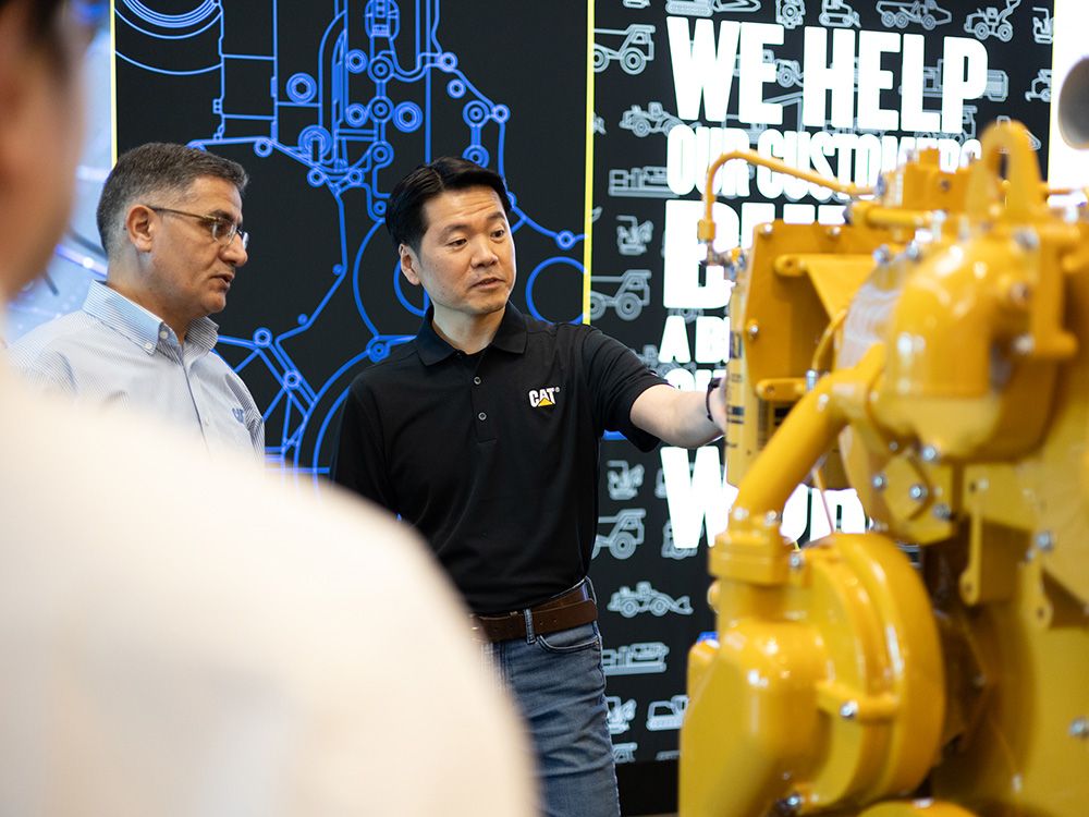 Employees examine an engine