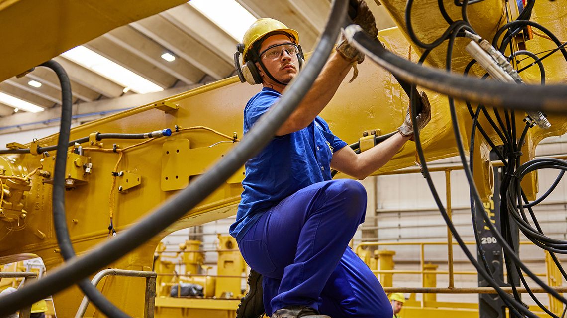 Man wearing blue uniform inpecting hoses
