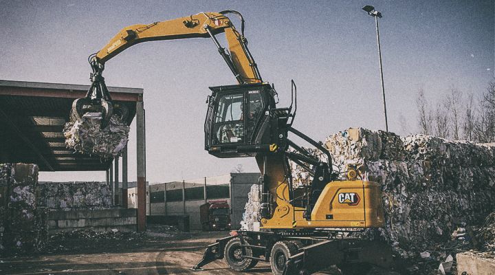 M3024 Excavator lifting concrete dividers on jobsite