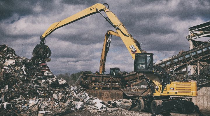 MH3050 Excavator lifting concrete dividers on jobsite