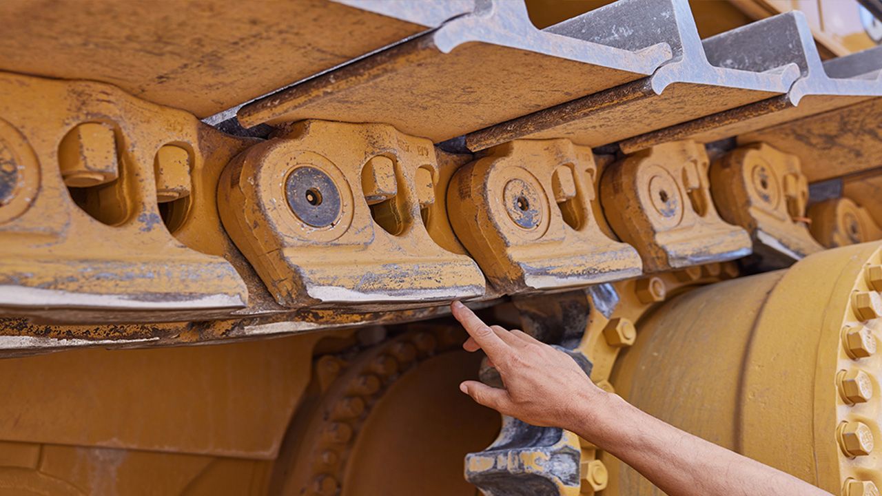 Mão apontando para um material rodante Cat