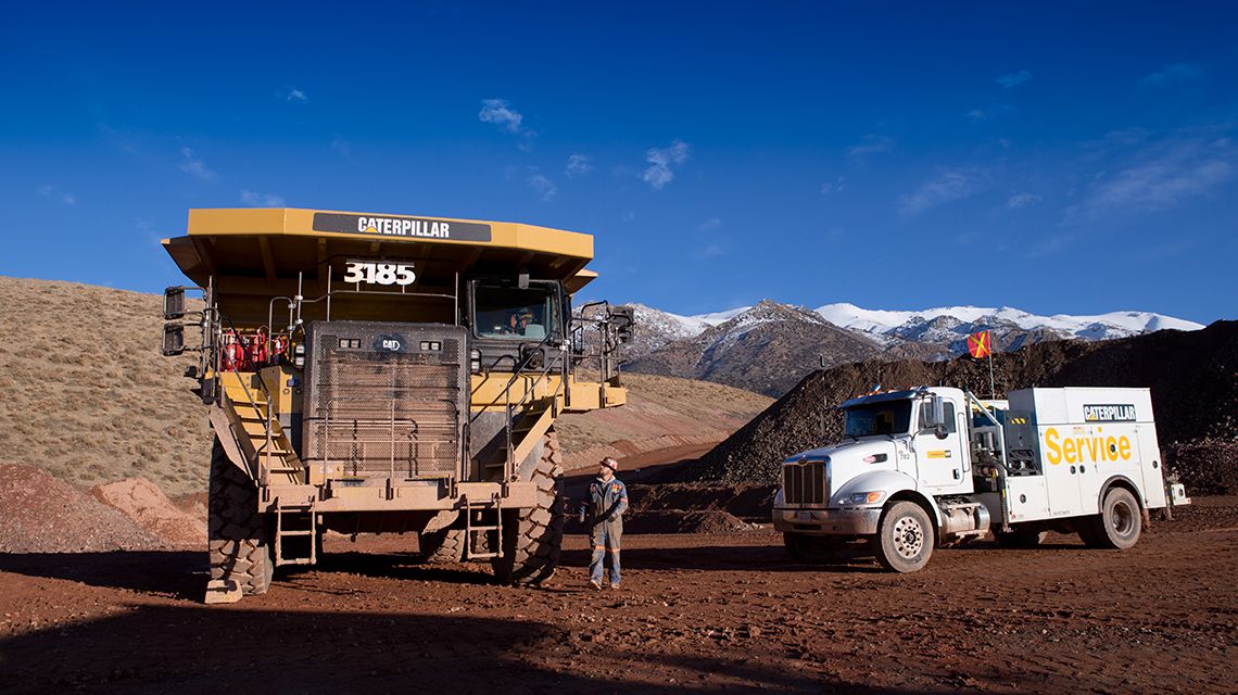 Camiones de servicio estacionados cerca de un camión para la minería grande