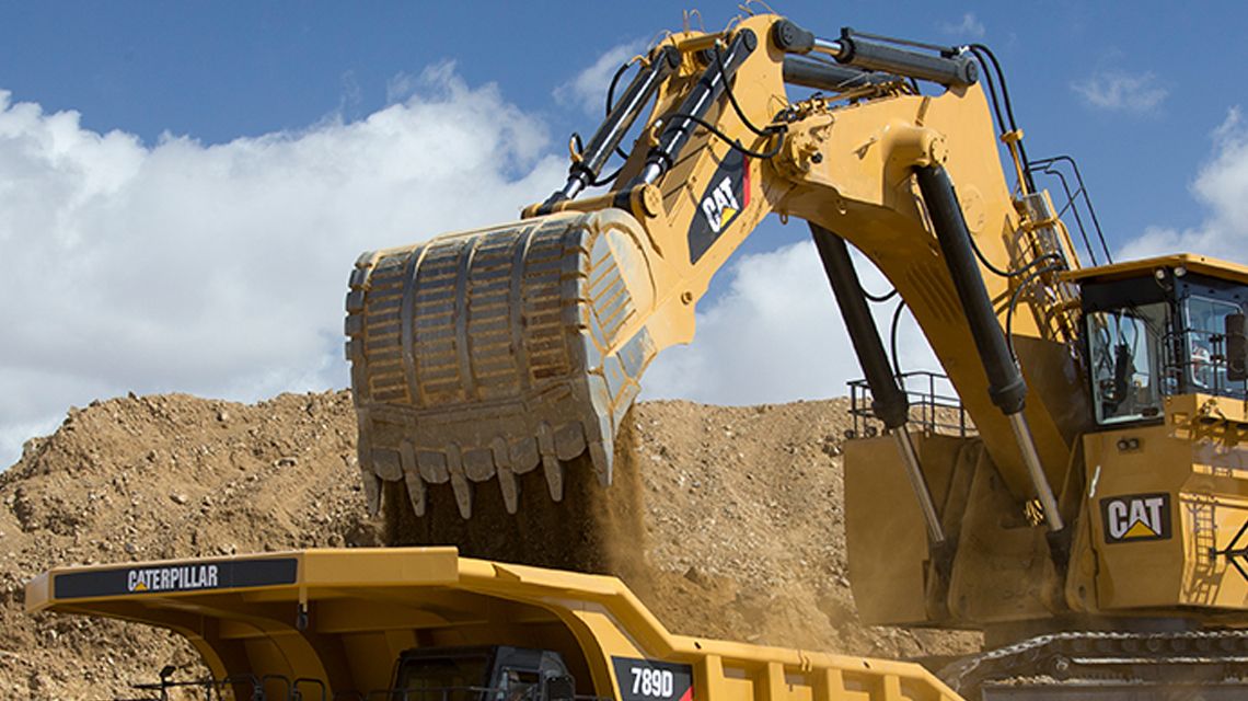 Escavadeira hidráulica de mineração Cat descarregando em um caminhão grande de mineração com caçamba e FPS da Cat