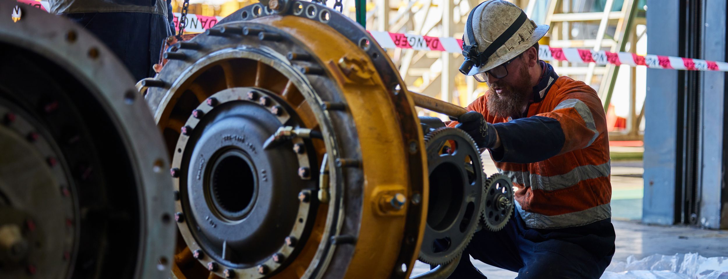 technician kneeling while working on a part