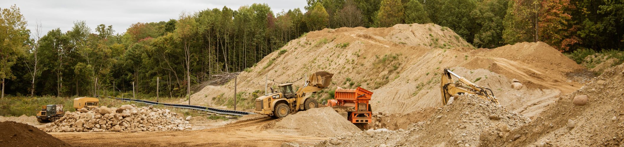 A sand and gravel jobsite with Cat machines at work
