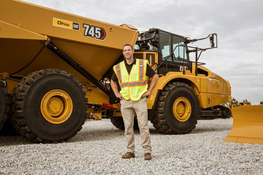 Ohio Cat Sales Rep Andrew Smith standing in front of a Cat 745 Articulated Truck