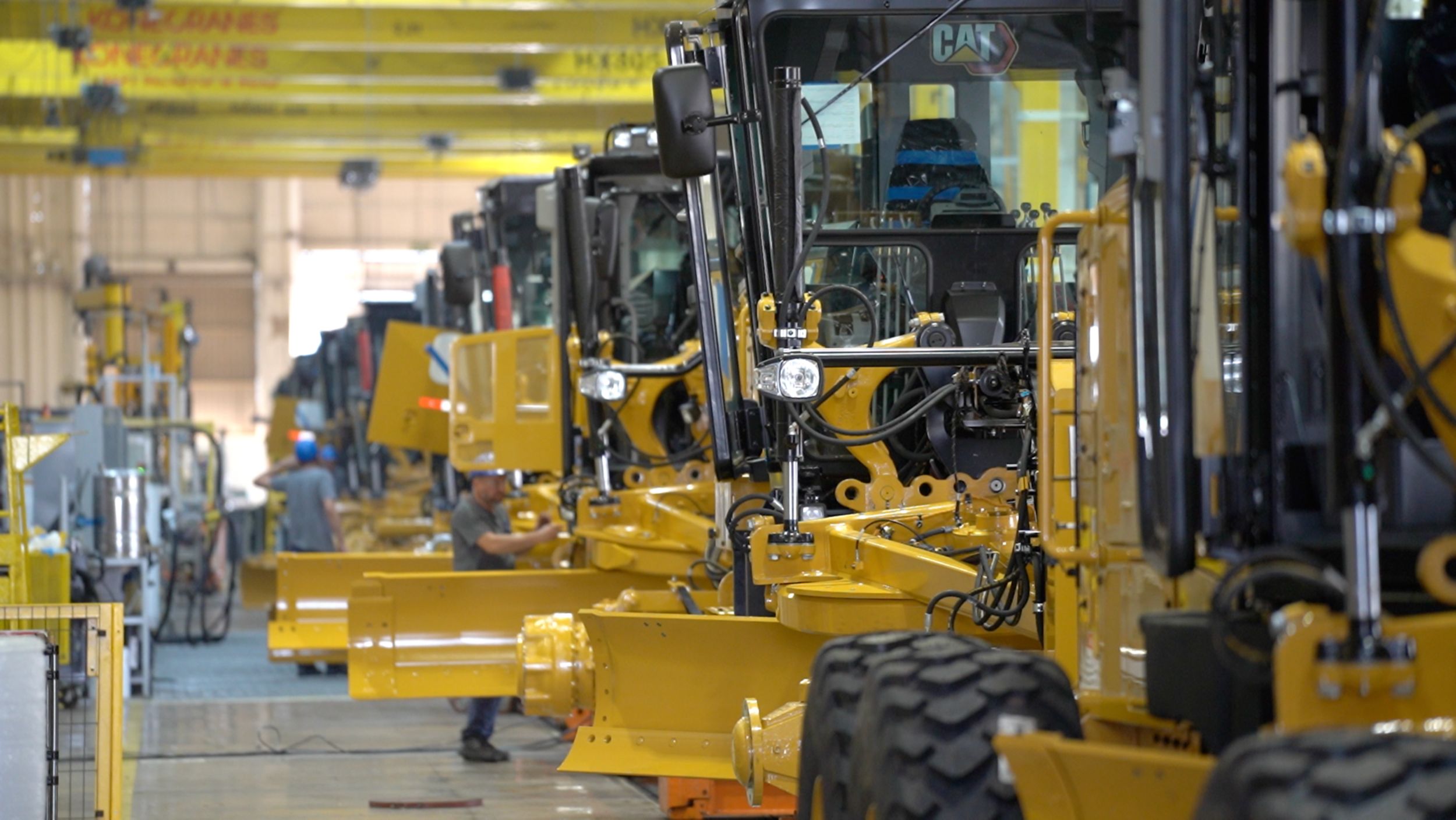 Motoniveladoras em linha de montagem dentro da fábrica