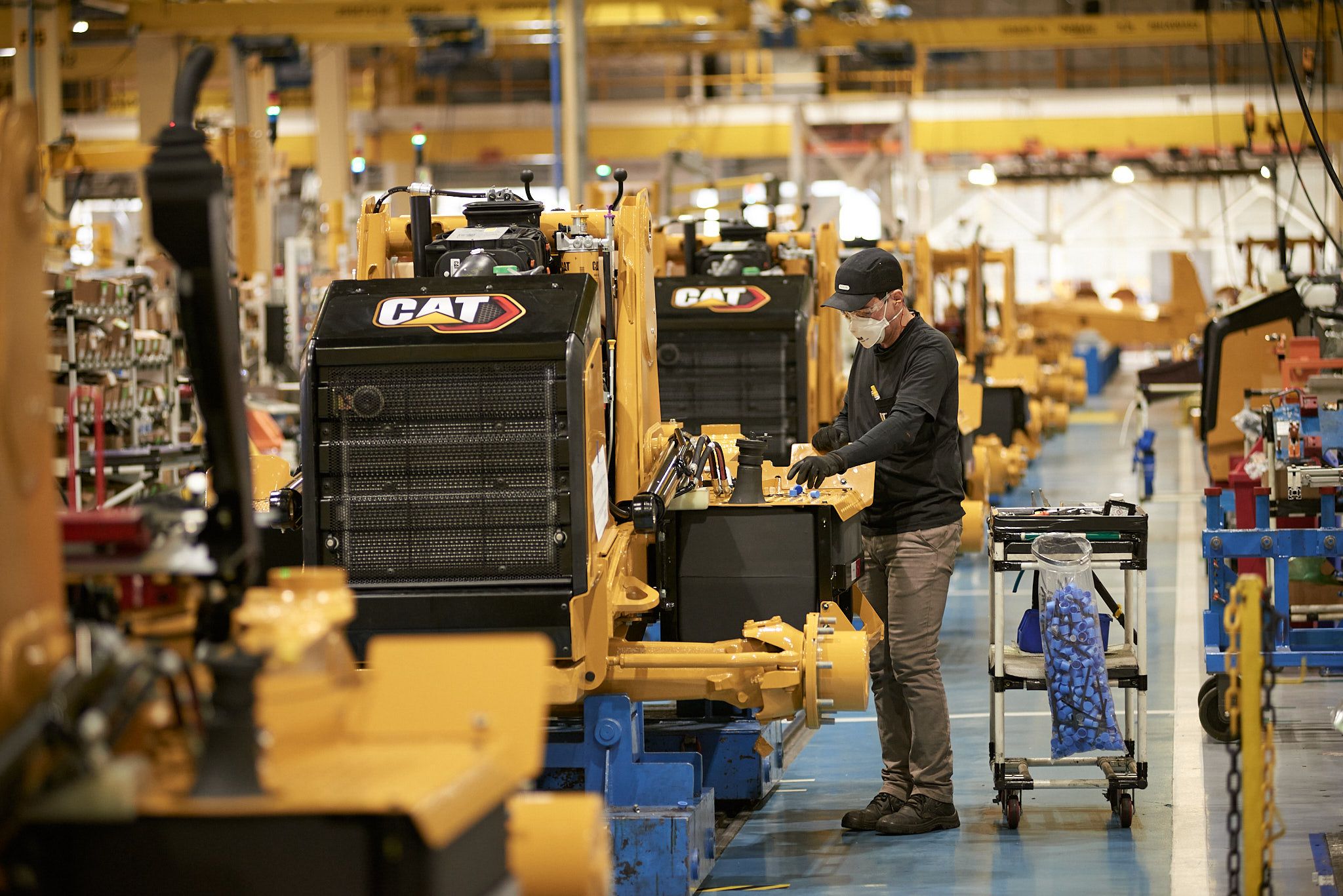 Trabalhador monta máquinas em linha de montagem