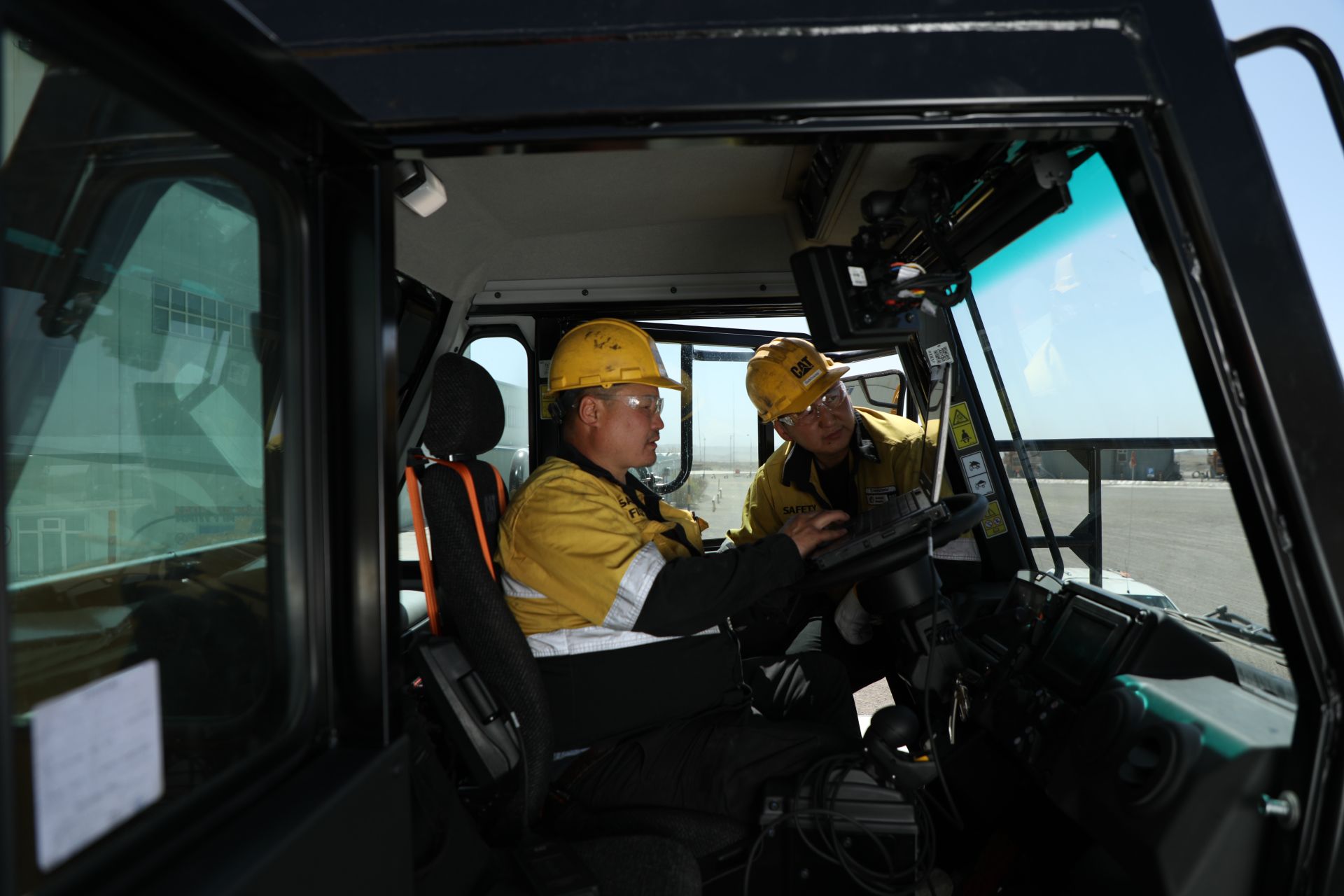 Two men talking throuhg the window of a vehicle