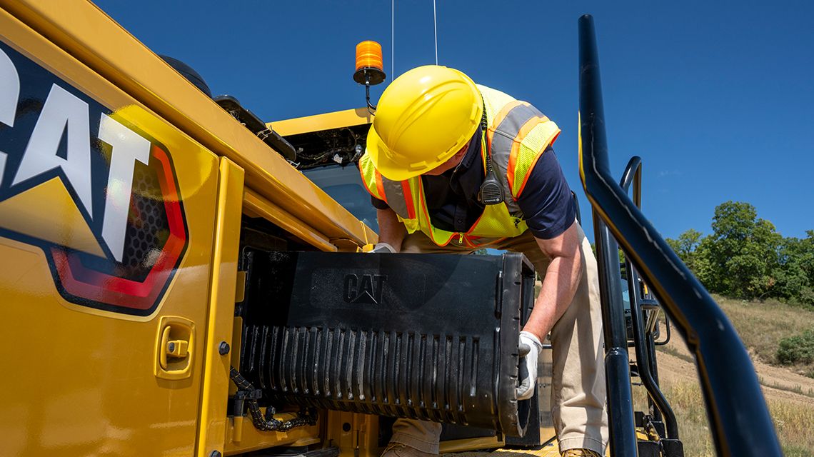 Man installing part into a mining Large Wheel Loader
