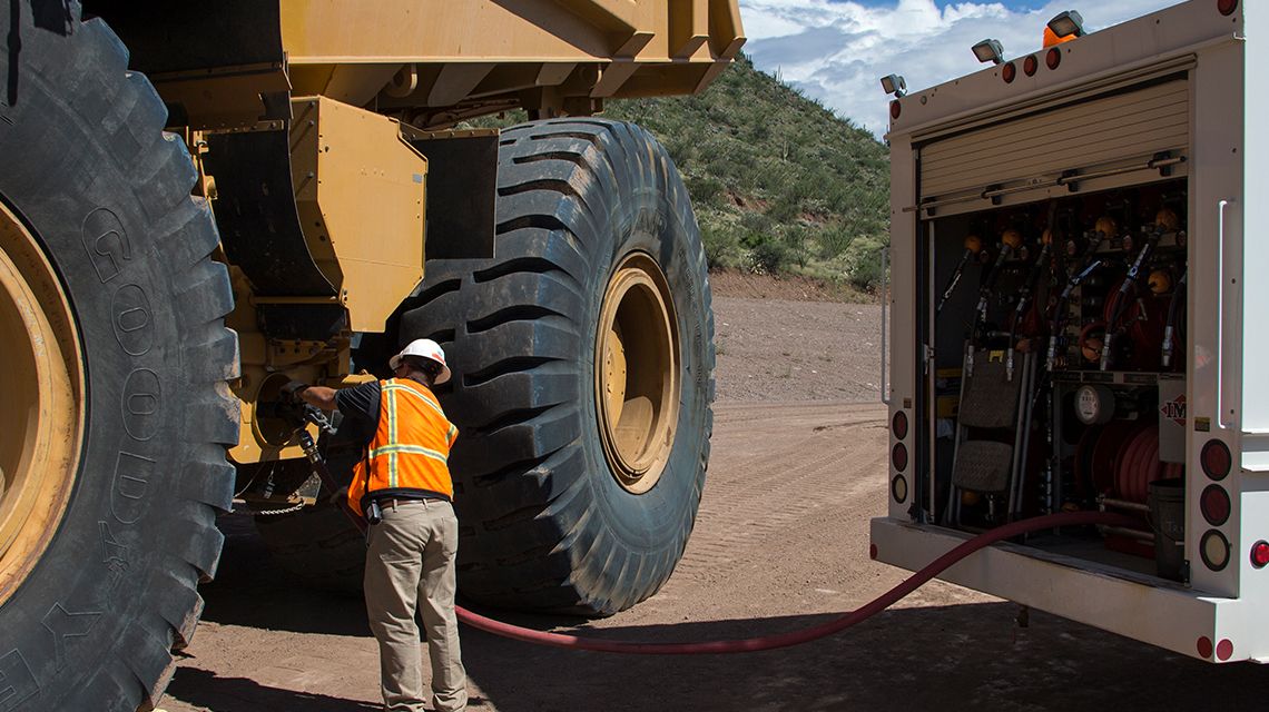 Man inspecting machine parts with a flashlight