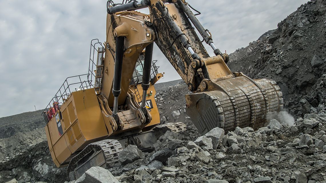 tilted view of Large Excavator digging rocks at mining site