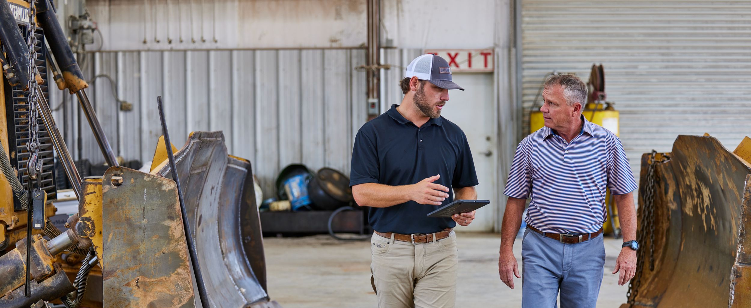 Two people walking and talking next to Cat Dozer