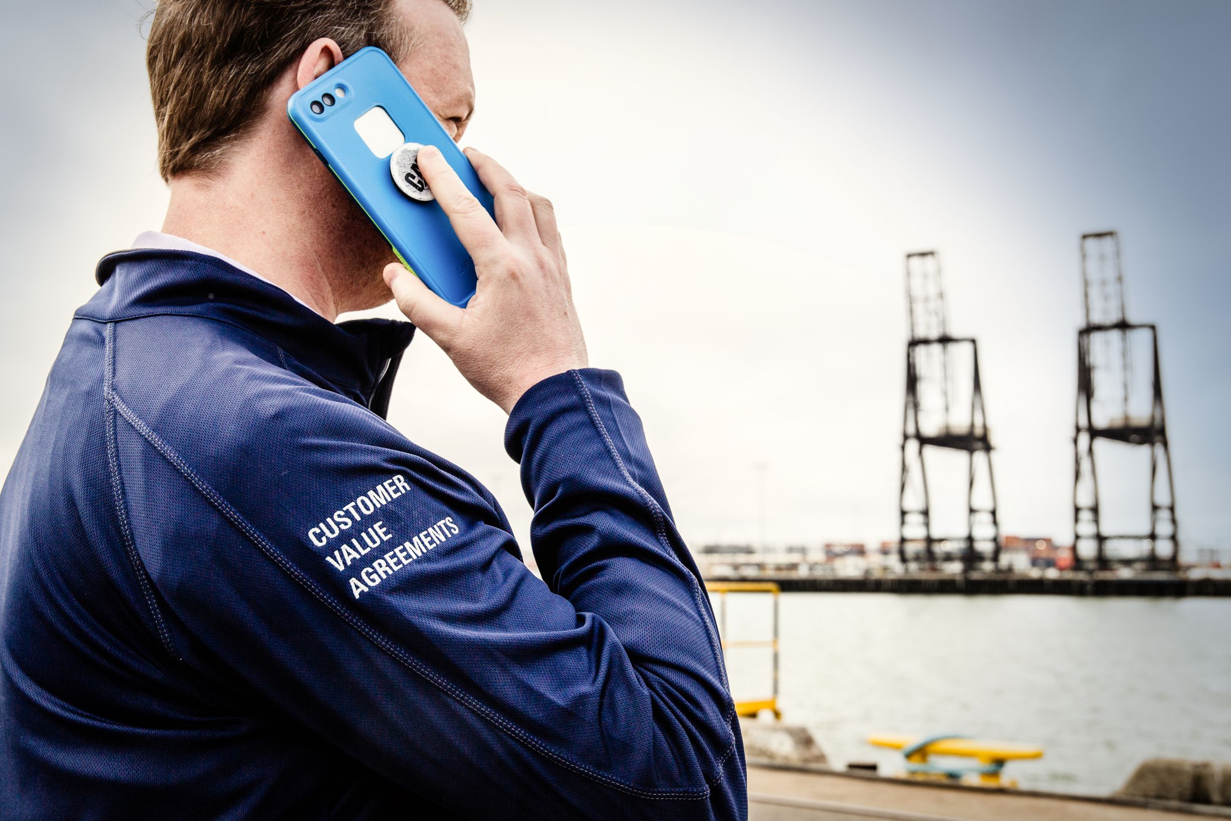 Cat dealer talking on a cellphone while on a dock