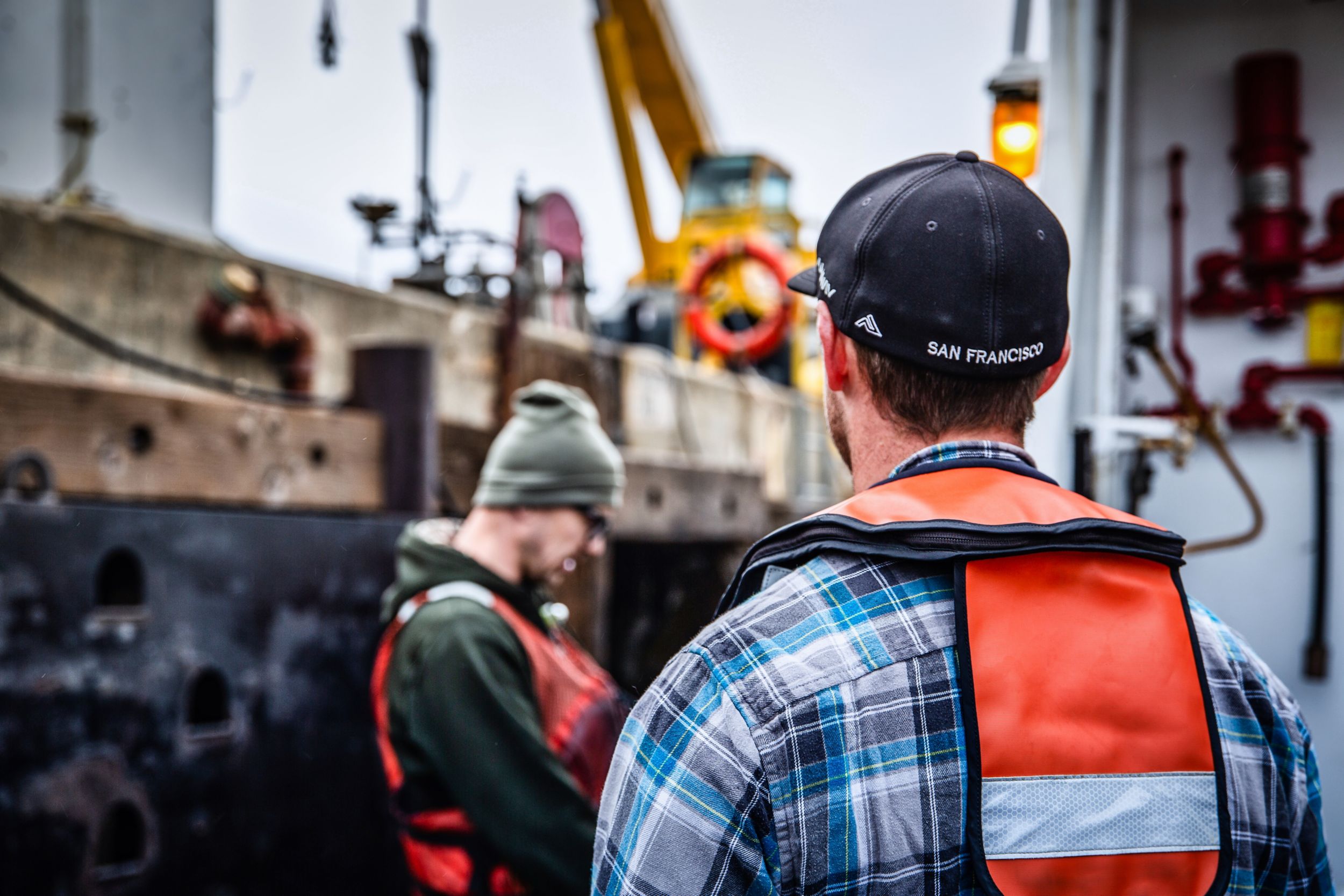 Two dock workers standing near a ship