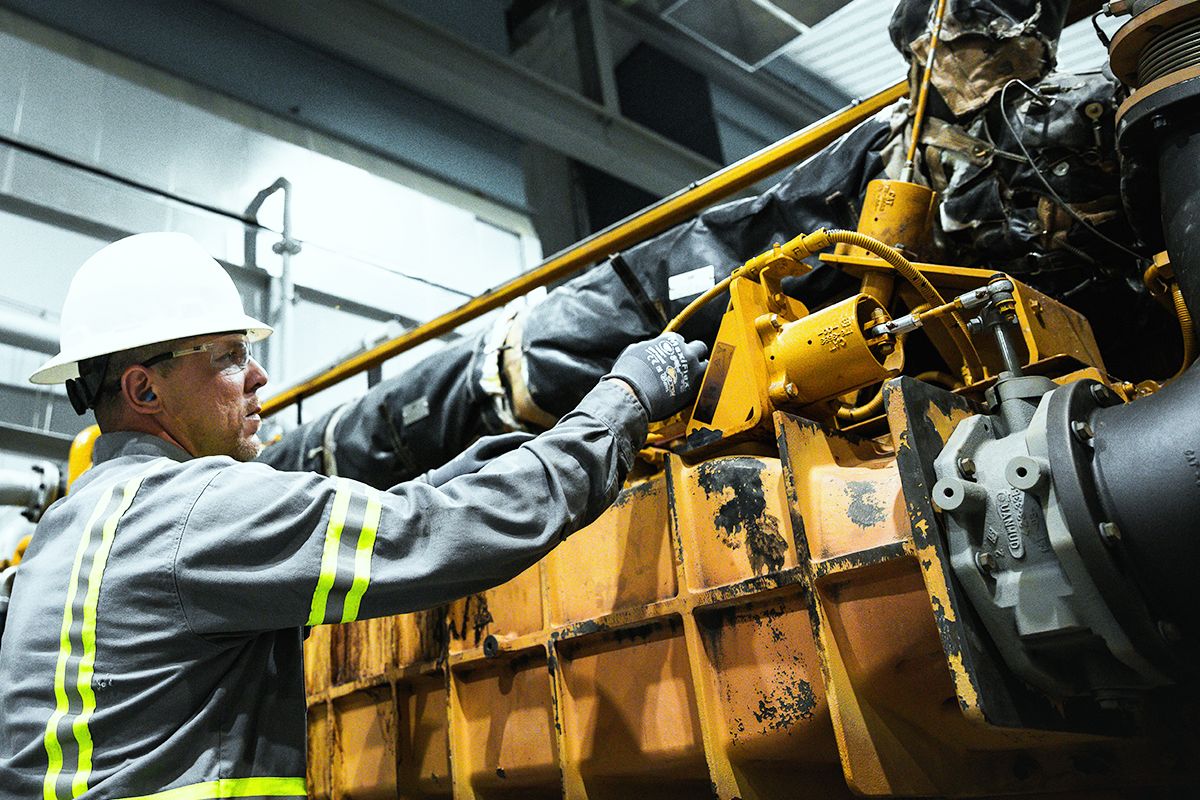 Engine operator performing maintenance on a Cat gas compression engine