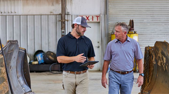 People walking and talking in front of Cat Dozer